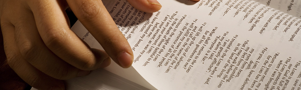 person turning page in Bible